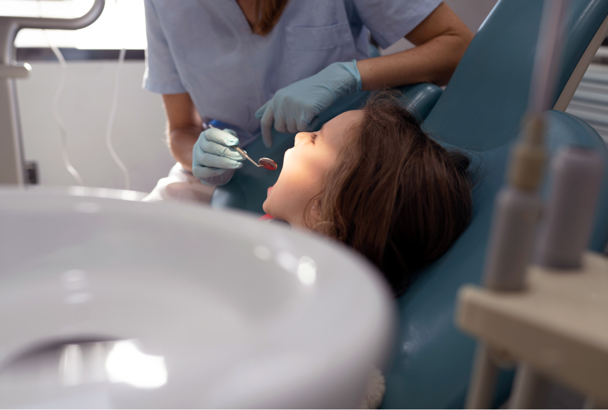 A dentist examines a young girl’s teeth.