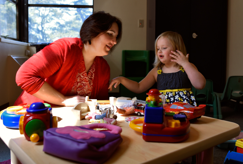 Mommy magic: Somer Bishop plays with her daughter Lila, 3, who does not have autism, at a table full of toys Bishop uses to evaluate children for autism.