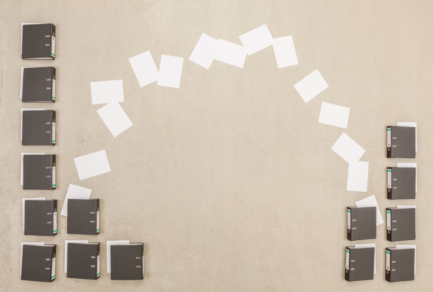 Stack of filing boxes with papers going from one to another.