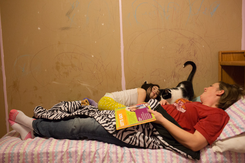 Victoria Green reads bedtime stories to her daughter Izzy in her room at their home in Madrid, Iowa on Thursday, January 19, 2017. Tired of constantly replacing drywall, Victoria and her husband Shane have allowed Izzy to draw on the wall instead. KC McGinnis for Spectrum