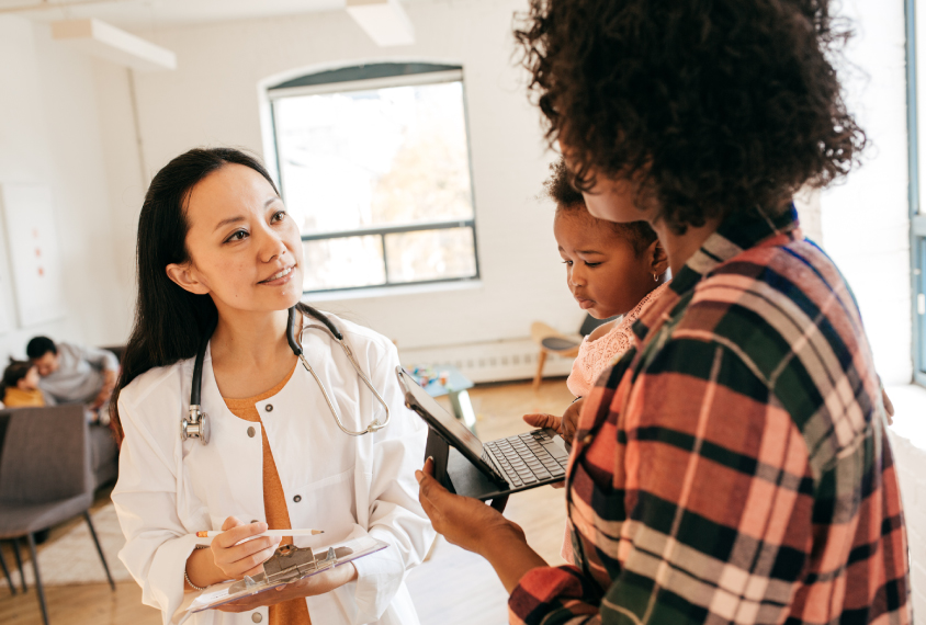 Doctor talking to mother and her toddler child.