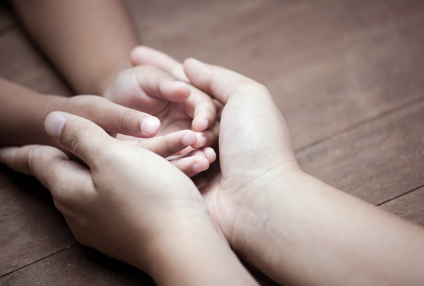 large adult hands holding small children's hands