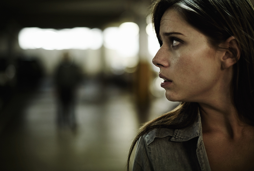 woman looking behind her with fearful expression