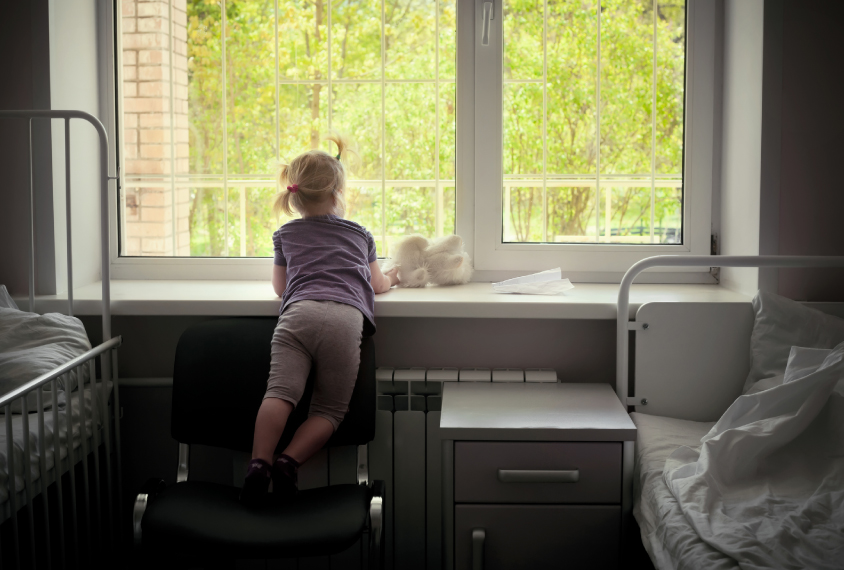 child looking out a hospital window