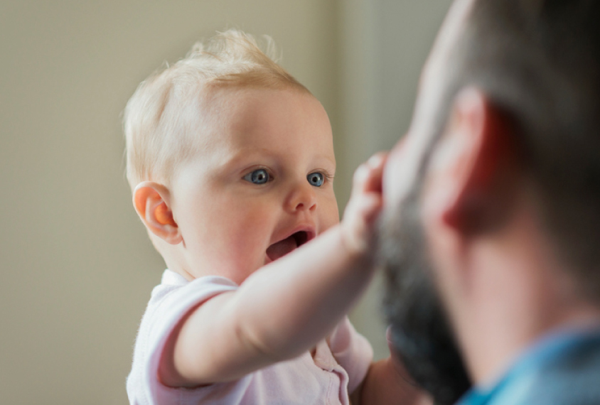 baby reaching out to touch father's face