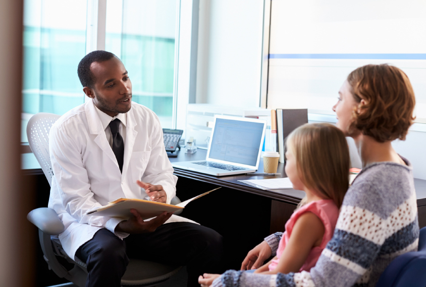 mother and daughter sitting across a doctor