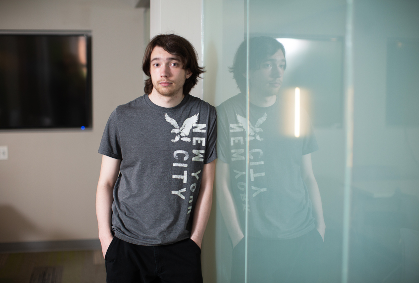 Photo: Kieran leans against a wall. He's wearing the same grey T-shirt.