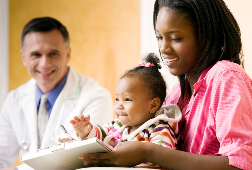 Toddler sitting in mother's lap at doctor's office