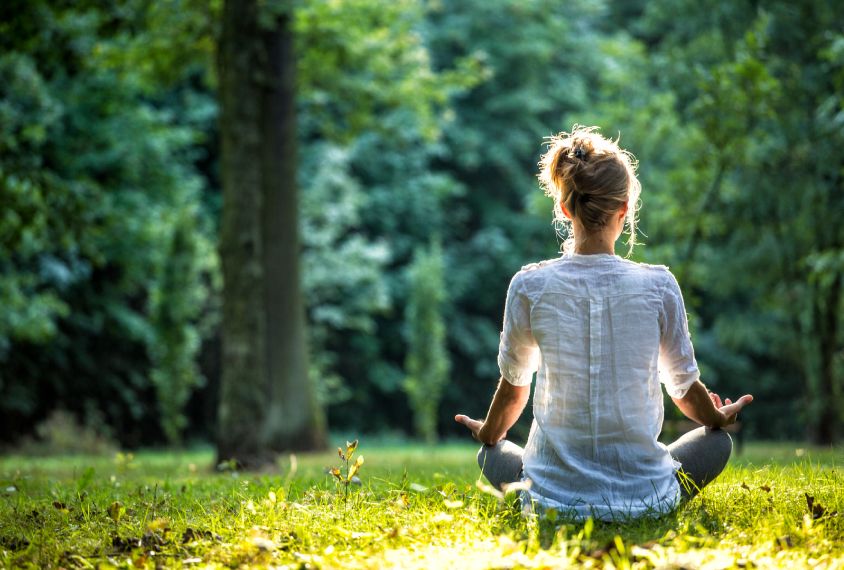 Woman doing yoga on grass field