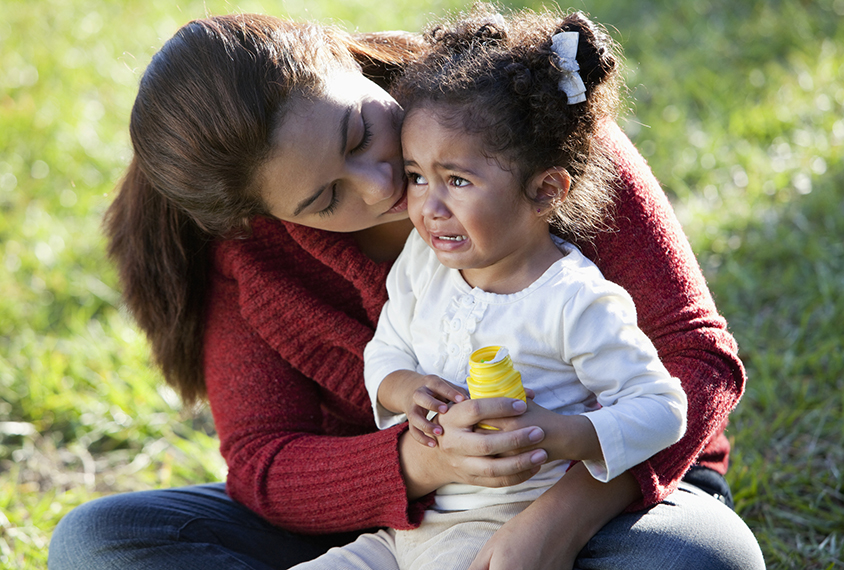 Mom holding crying toddler