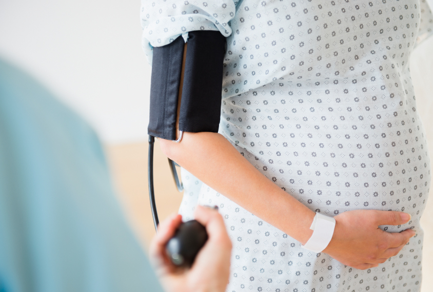 Pregnant woman has her blood pressure taken.