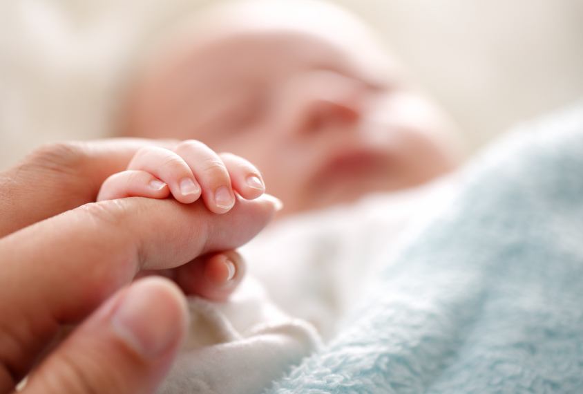 Newborn fingers on mother's hand.