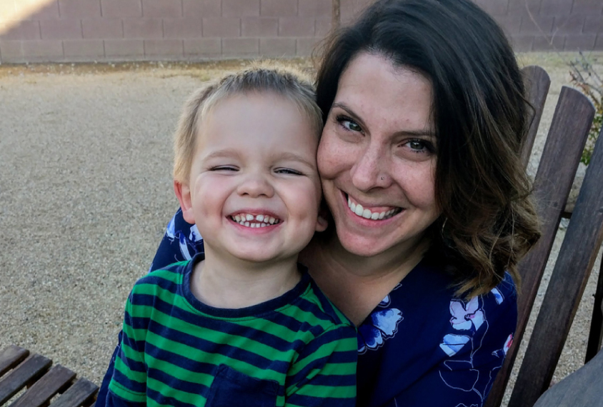 smiling little boy on his smiling mother's lap. 