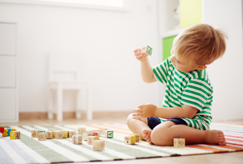 A young boy plays with blocks