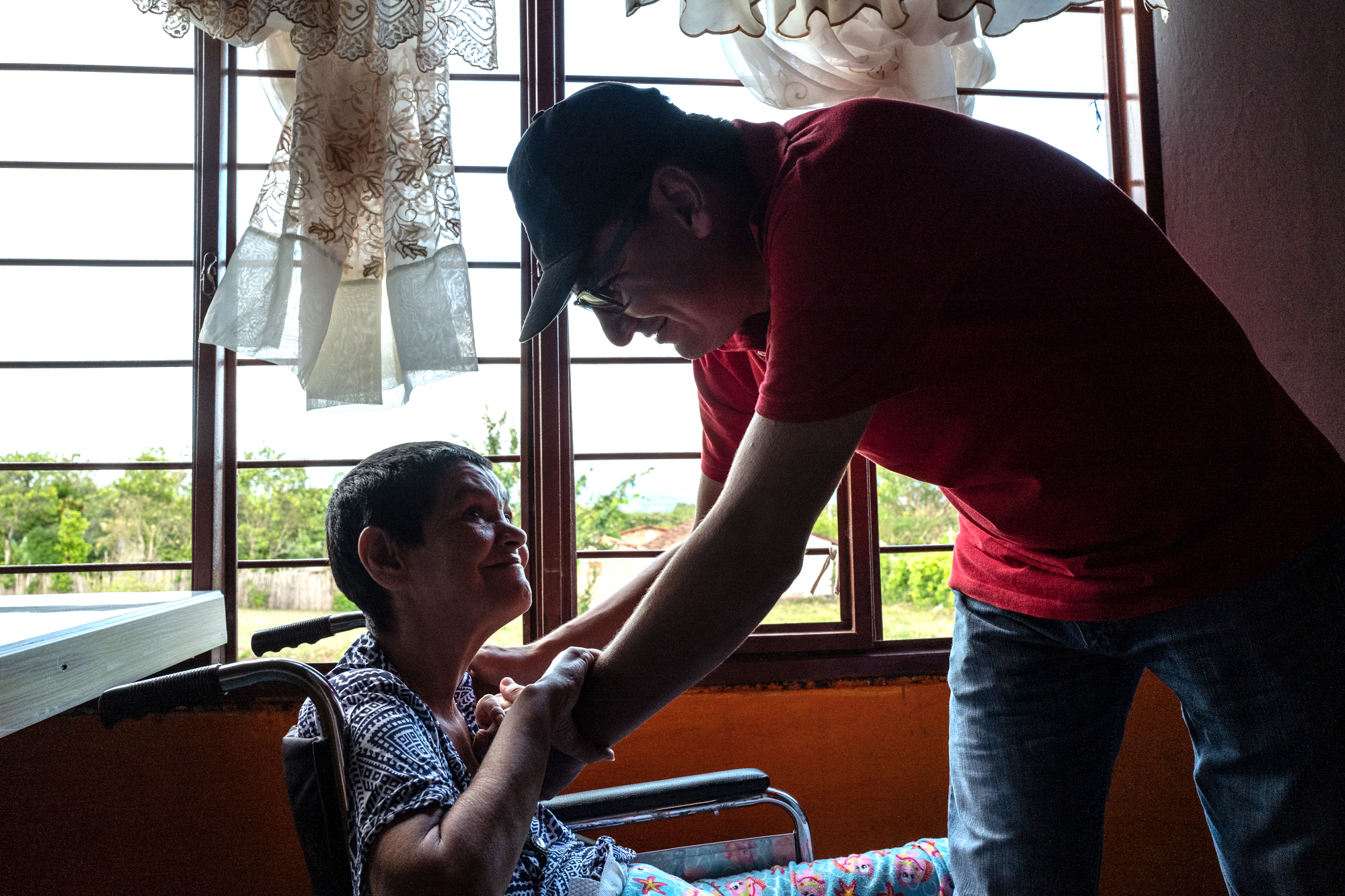 Professor Wilmar Saldarriaga comforts Julieta Triviño at her home in Ricaurte , Valle del Cauca on July 28, 2018.