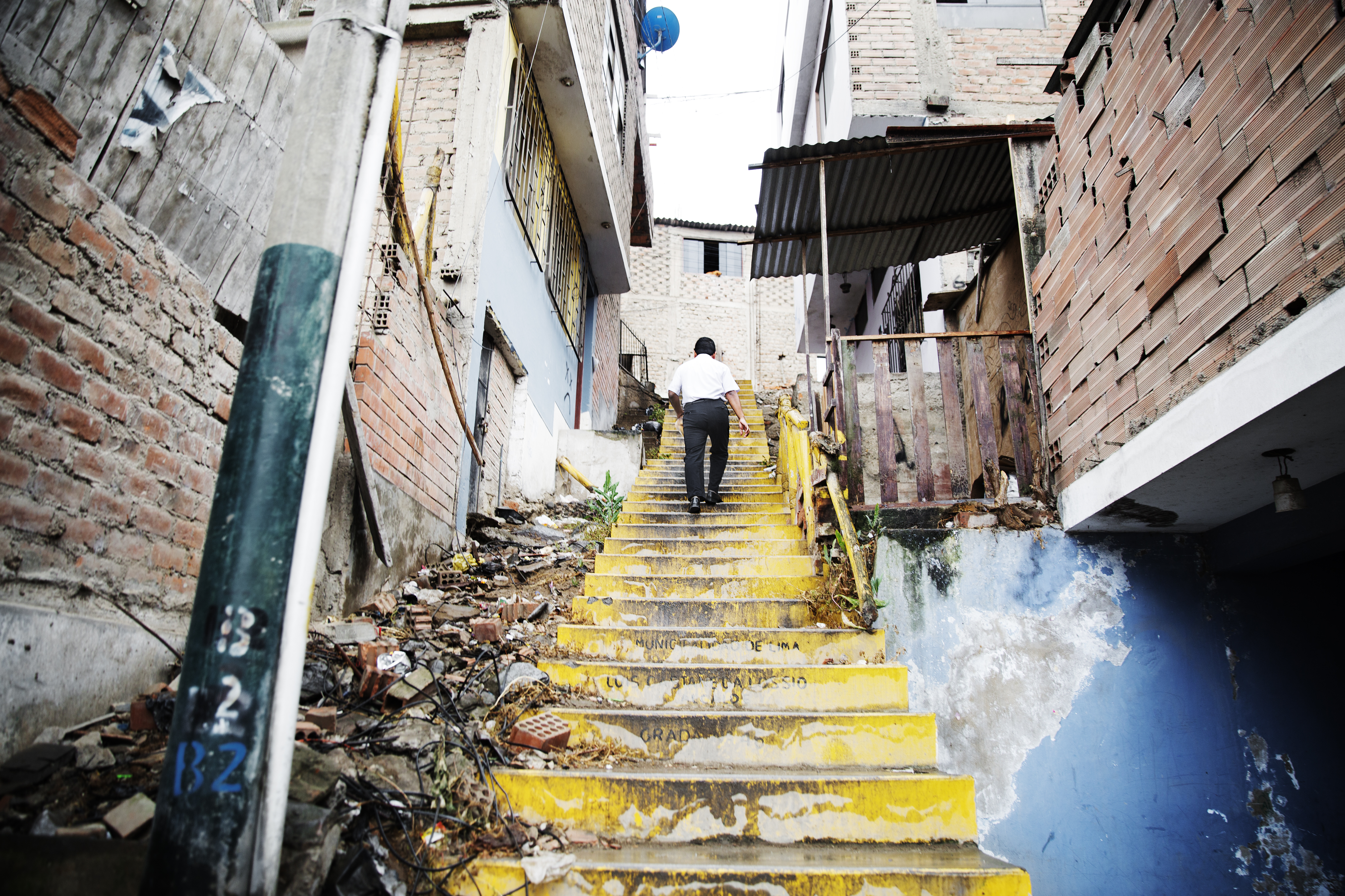 A man walks up a decrepit staircase in his neighborhood in Lima, Peru.