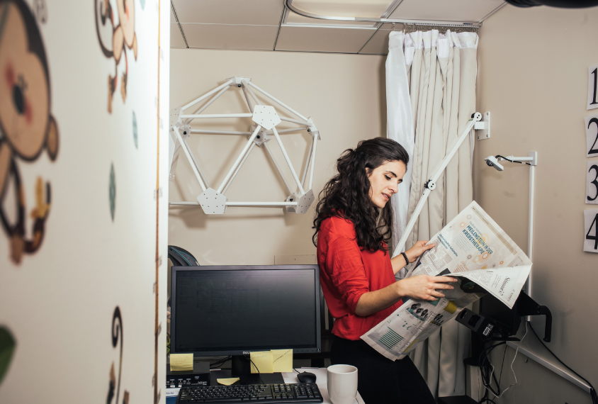 Gabriela Roseblau reading a German newspaper in her lab.