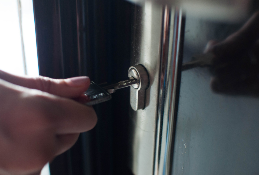 Hand with key opening door a residence