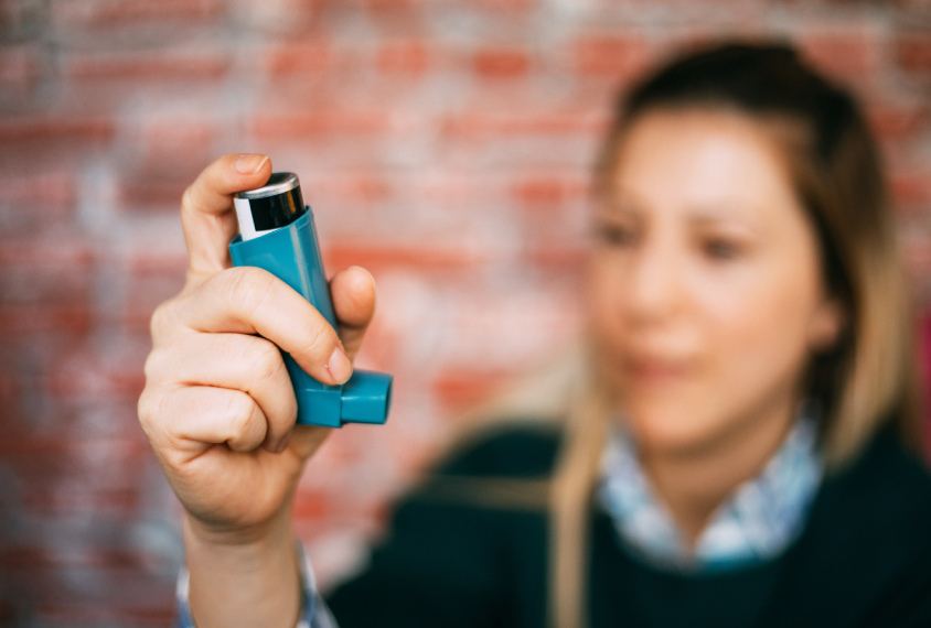 Woman holding inhaler.