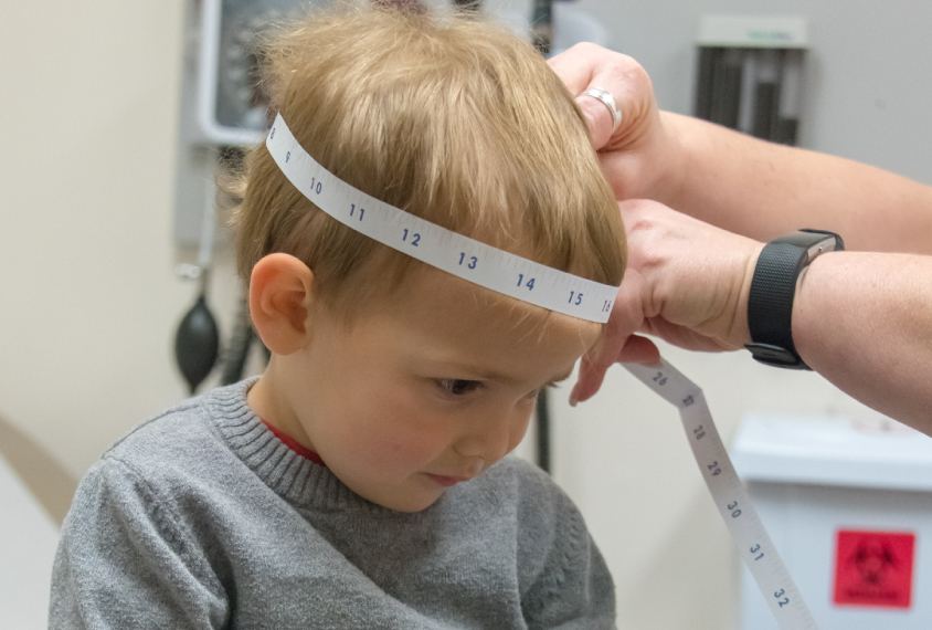 Toddler having head measured at clinic