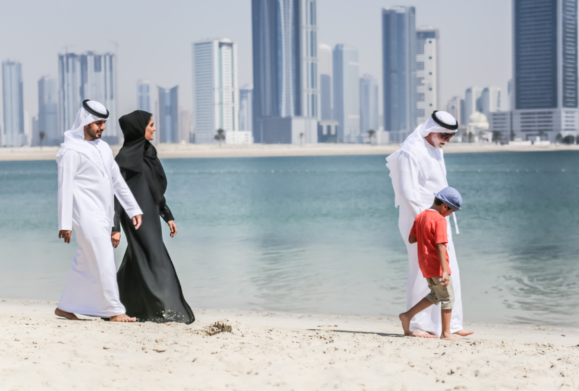 Arab family walking on the autumn beach