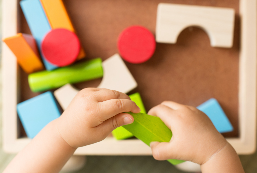 Toddler's hands playing with educational toys