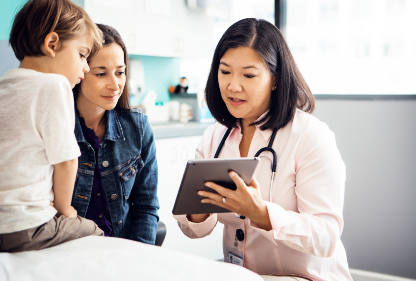 Female doctor with young patient and his mother