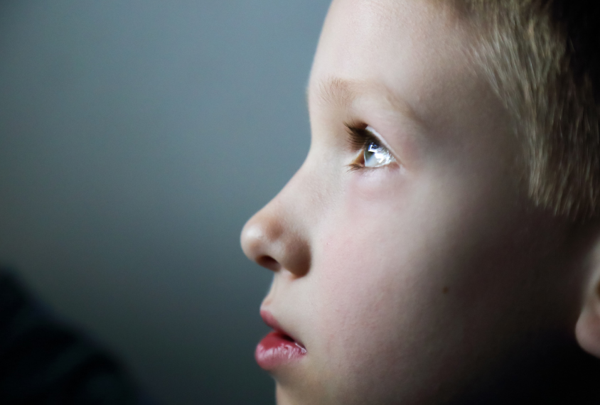 four year old looks at something out of frame.