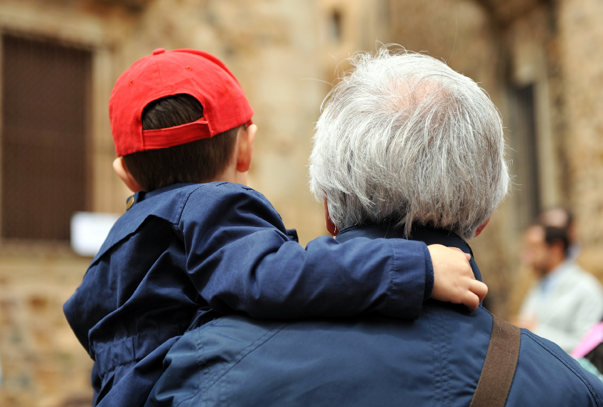 Older father carries son in reed baseball cap