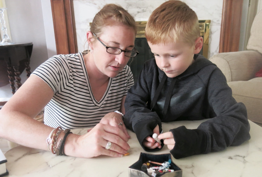 Mother and son play with small toys on tabletop