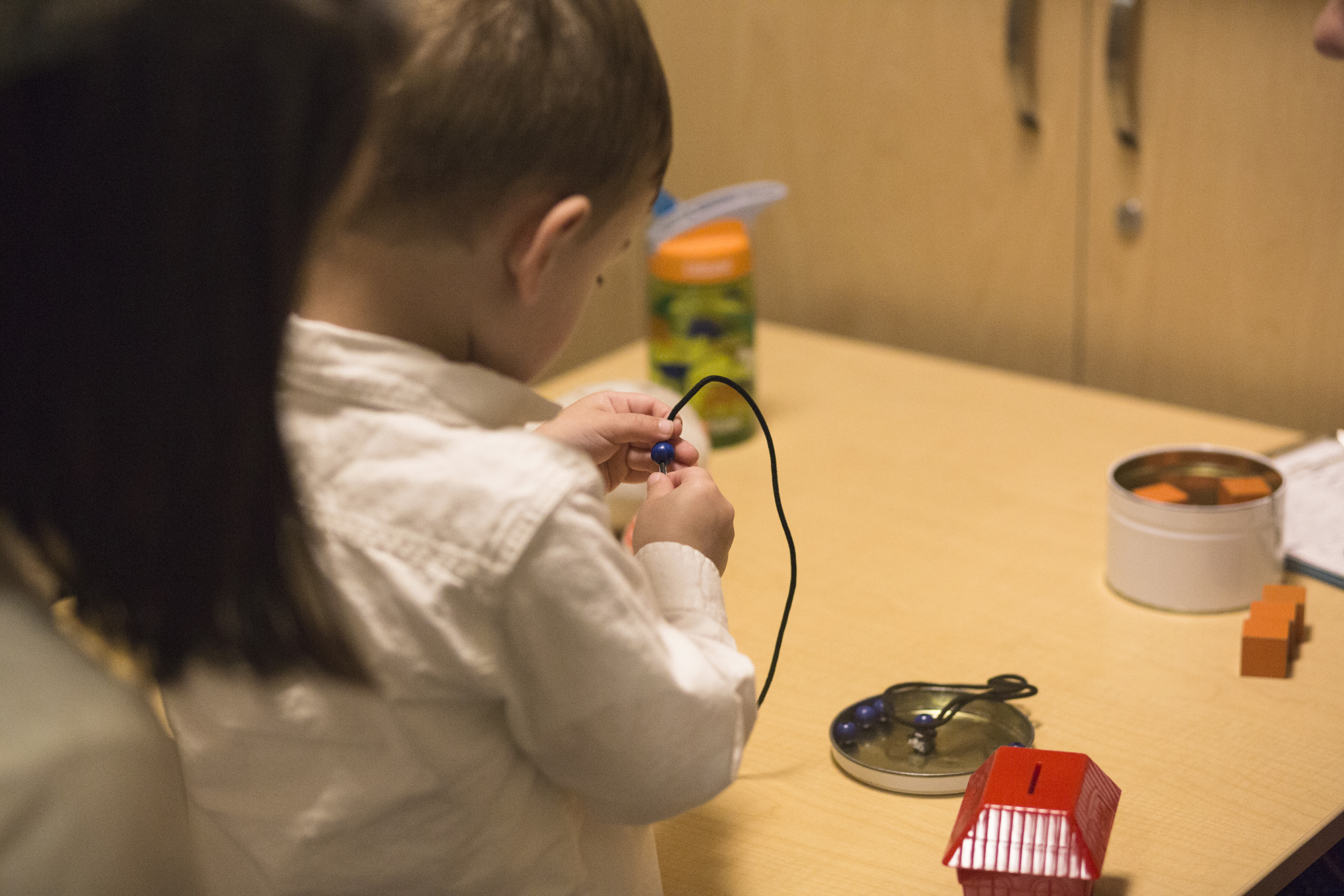 Photo: Owen's mom looks over his shoulder while he plays with a toy.