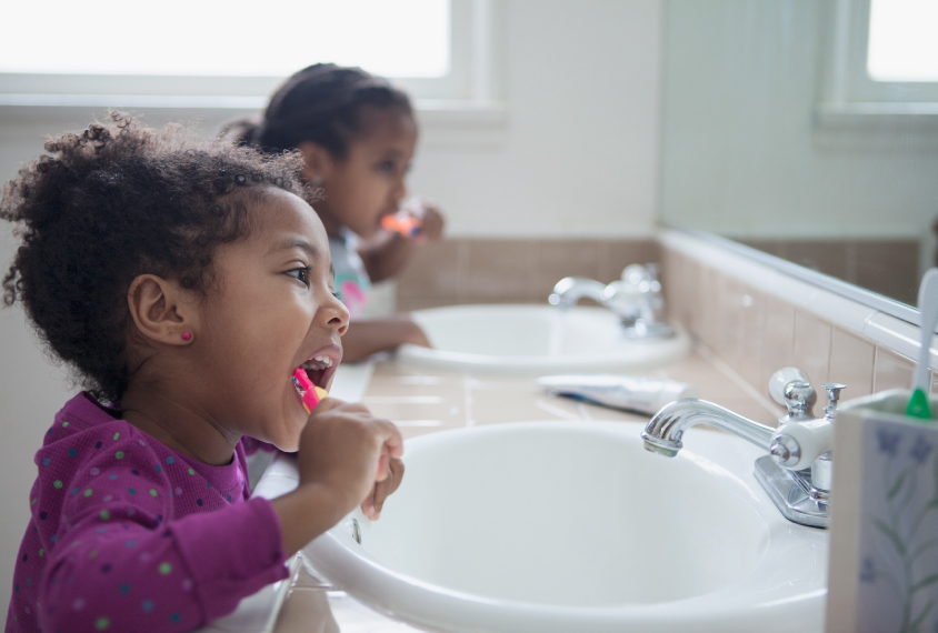Two children brush teeth in bathroom