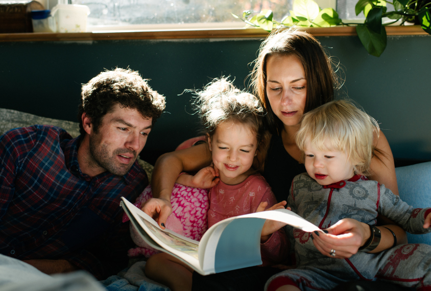 Young family of four reading together