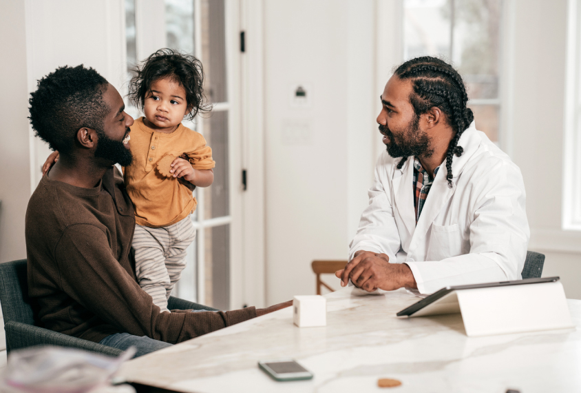 Family with toddler talking to clinician