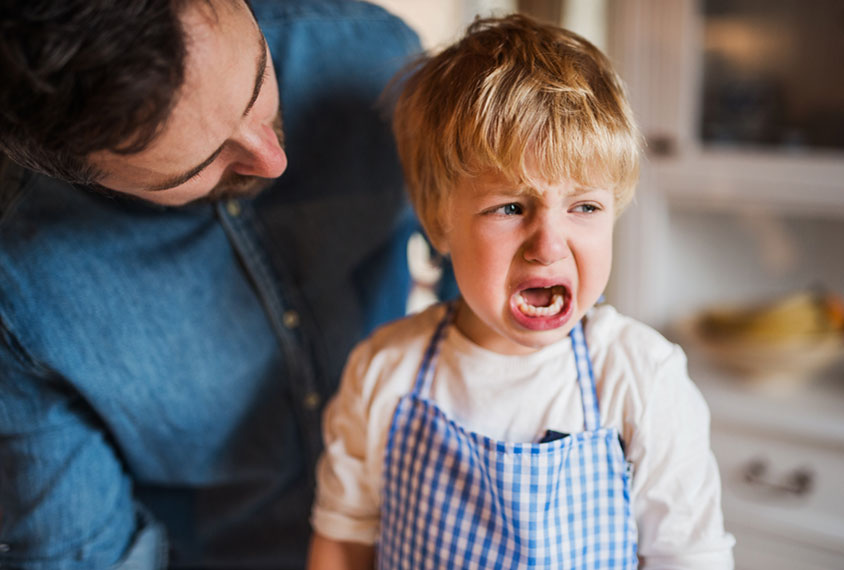 Toddler cries, looking away from parent