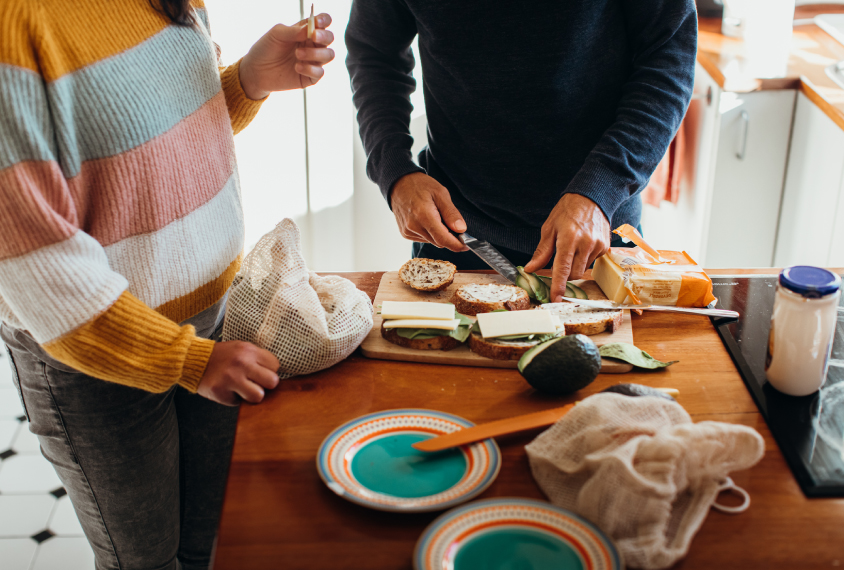 woman and man preparing food in a kitchen.