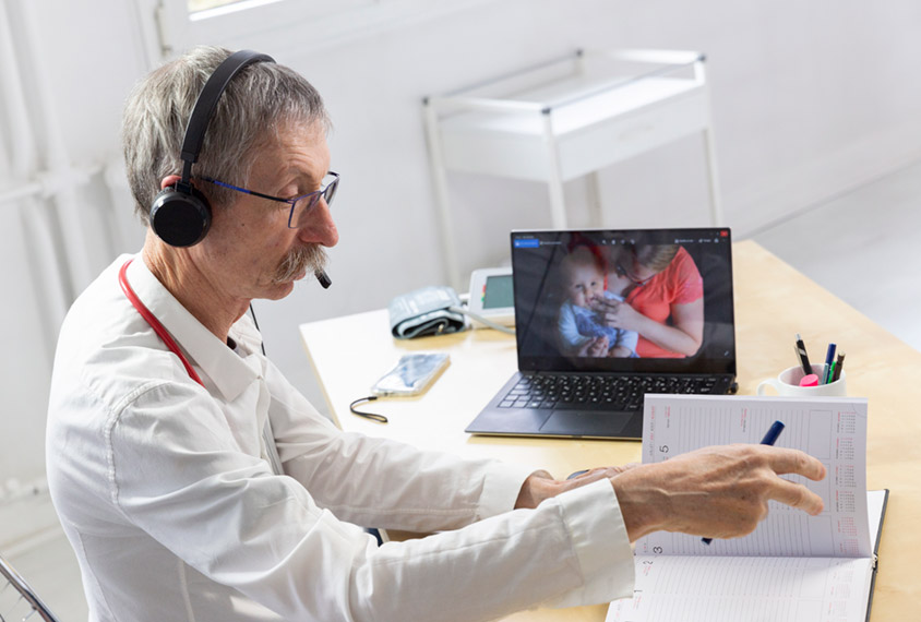 doctor with remote patients on screen in his office