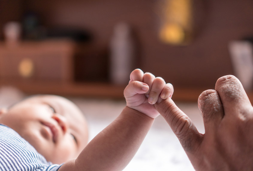 baby grasping an adult hand