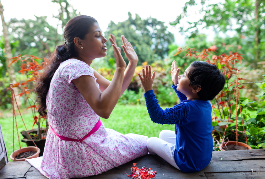 Mother and child play game using hands