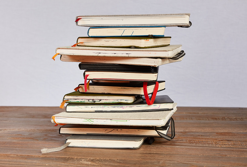 collection of sketchbooks stacked up