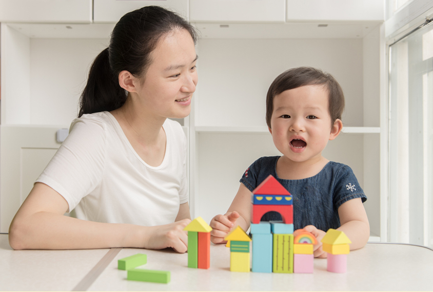 Toddler vocalizing next to parent.