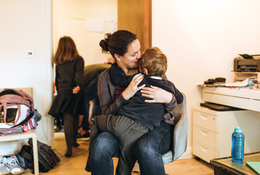 Mother affectionately hugging young son.