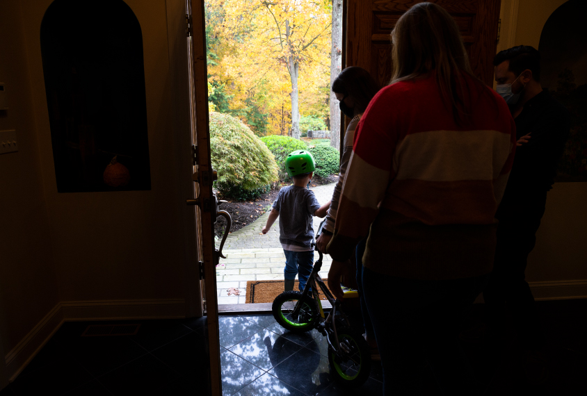 Owen leaving his home for a bike ride, followed by his therapists and teachers.