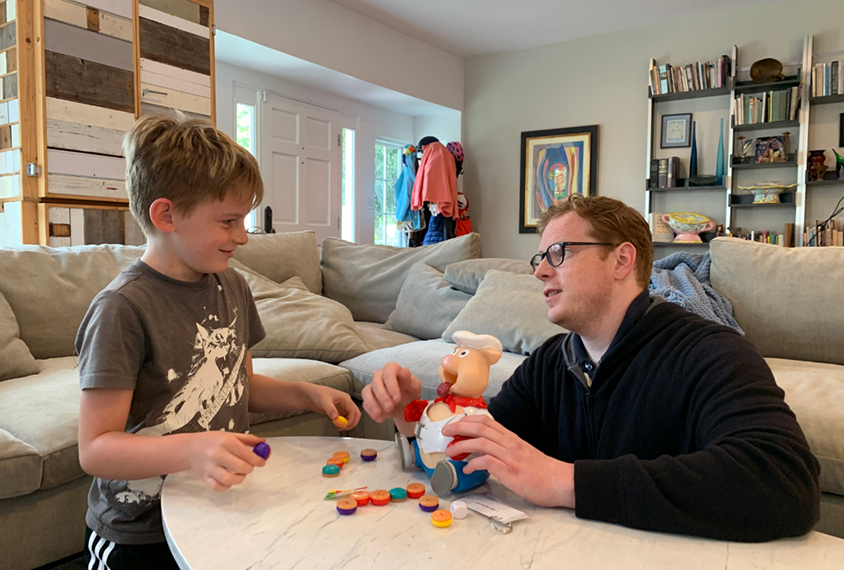 boy and his father with learning toys in living room.