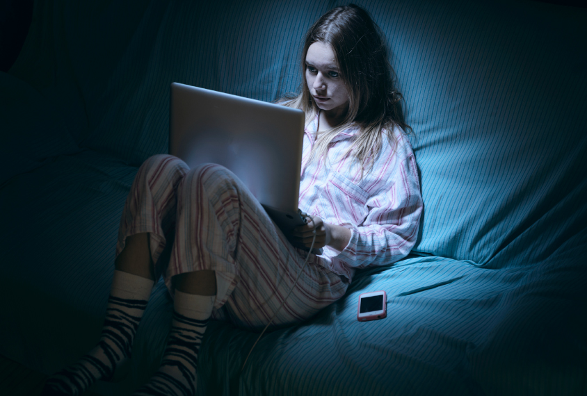 Teen girl up at night, looking at her computer.