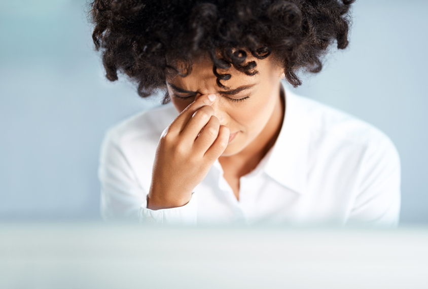 Woman is holding her fingers to her forehead in pain.