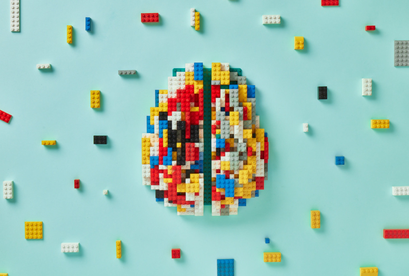 Brain composed of legos with various legos scattered around