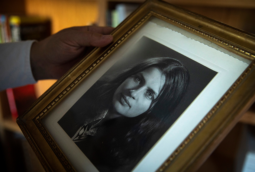 Eric Fombonne holds a framed portrait of his deceased sister.