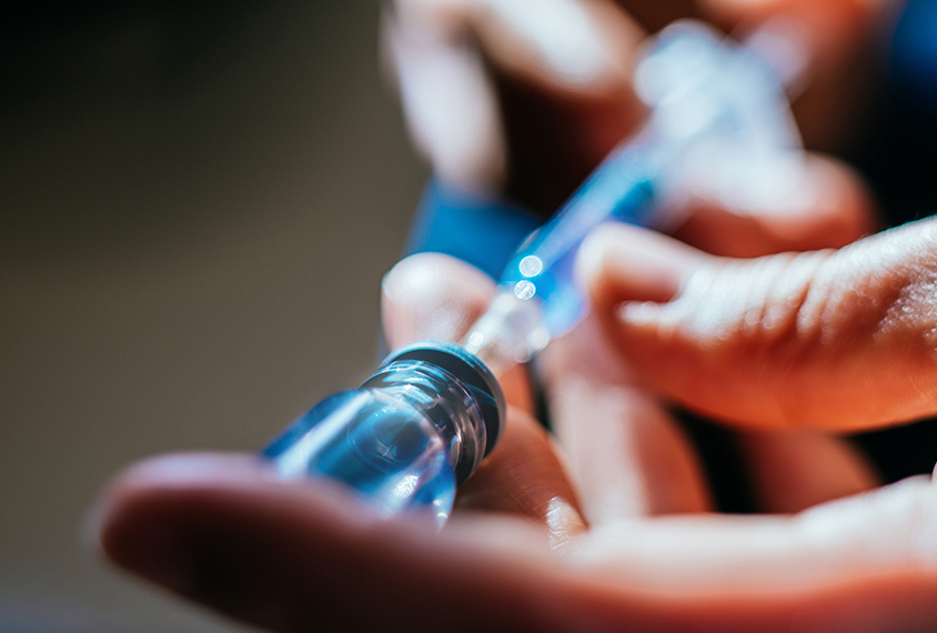 Medicine being drawn out of a vial with a syringe.