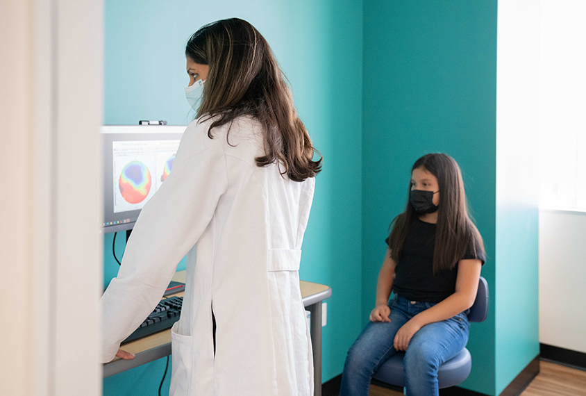 Dr. Jeste with a patient, reviewing data on a computer monitor. .